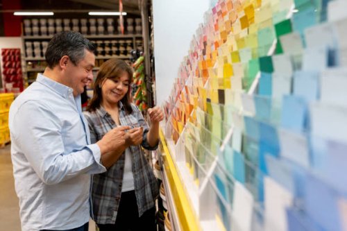loving couple at hardware store choosing a color to paint their house - home decoration stock pictures, royalty-free photos & images