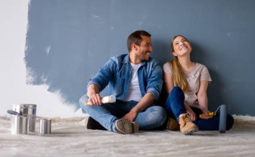 loving couple having fun renovating their house and painting the walls - home decoration stock pictures, royalty-free photos & images