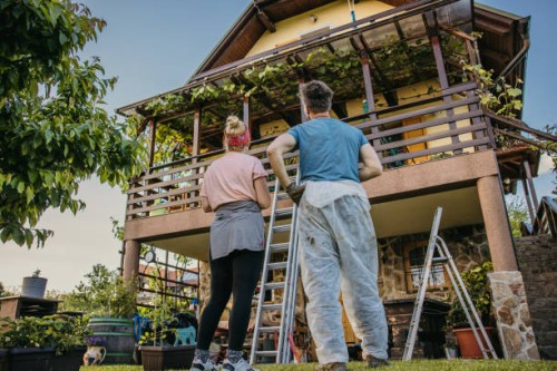 low angle adult couple checking their balcony fence after hard painting work - home decoration stock pictures, royalty-free photos & images