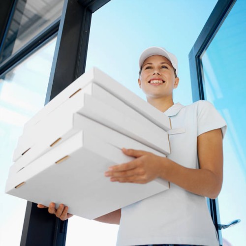 low angle view of delivery woman holding stack of pizza's - junk food stock pictures, royalty-free photos & images