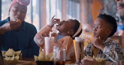 lunch, black family and eating food in in restaurant with smile, fun and hungry kids at table. milkshake, mother and children in cafe sharing meal with burger, drinks or bonding on weekend in africa - junk food stock pictures