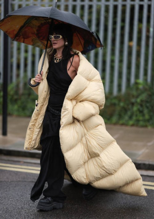 Magda Kaczmarska was seen wearing black plateau shoes, black oversized trousers, a black tank top, yellow gold jewelry, yellow shades, a black...