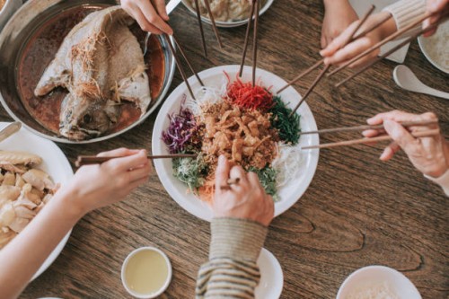 malaysian chinese family chinese new year reunion dinner having traditional dishes raw fish lau sang yee sang - food stock pictures, royalty-free photos & images
