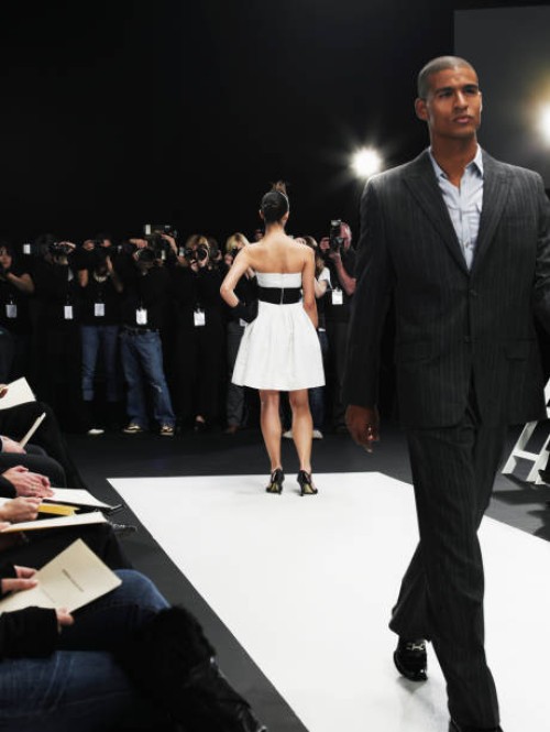 male and female models on catwalk, group of photographers in distance - fashion stock-fotos und bilder