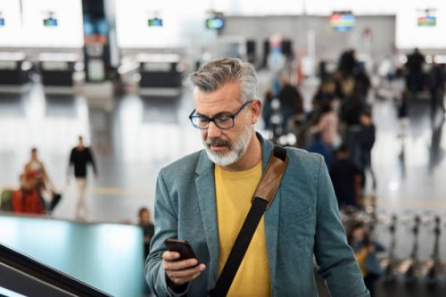 male commuter using smart phone on escalator - travel stock pictures, royalty-free photos & images
