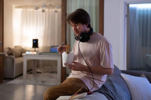 male musician eating delivery food - junk food stock pictures, royalty-free photos & images