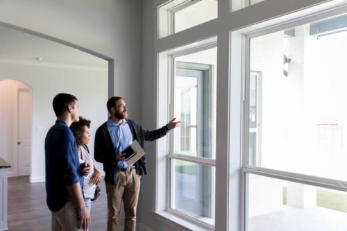 male real estate agent shows a couple a beautiful home - home decoration stock pictures, royalty-free photos & images