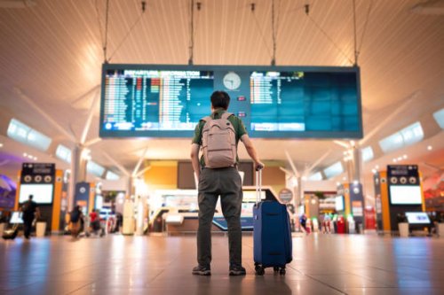 male tourist looking at arrival and departure board at kuala lumpur international airport - travel stock pictures, royalty-free photos & images
