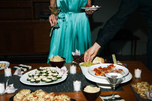 man and woman eating appetizers at cocktail party - food stock pictures, royalty-free photos & images
