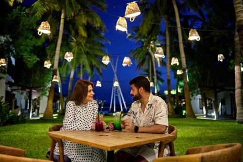 man and woman enjoying drinks sitting in resort garden - garden decoration stock pictures, royalty-free photos & images