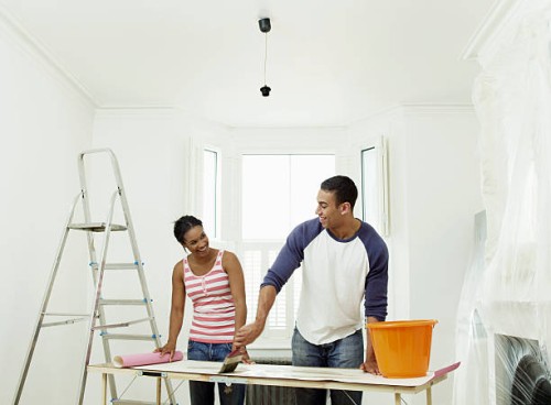 man and woman preparing to hang wallpaper - home decoration stock pictures, royalty-free photos & images