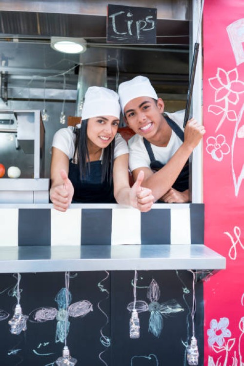man and woman work at a food truck preparing fast food - junk food stock pictures, royalty-free photos & images