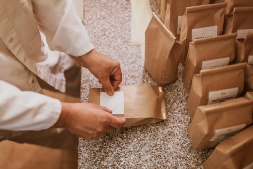 man applying label on paper bags in mill - food stock pictures, royalty-free photos & images