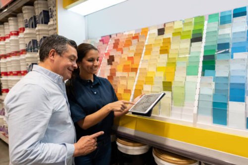 man at hardware store buying paint and talking to the saleswoman - home decoration stock pictures, royalty-free photos & images