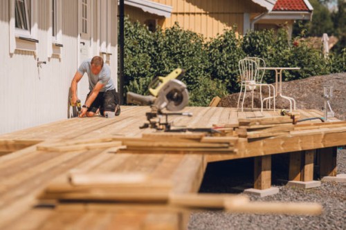 man building a wooden patio deck outdoors in his garden - home decoration stock pictures, royalty-free photos & images