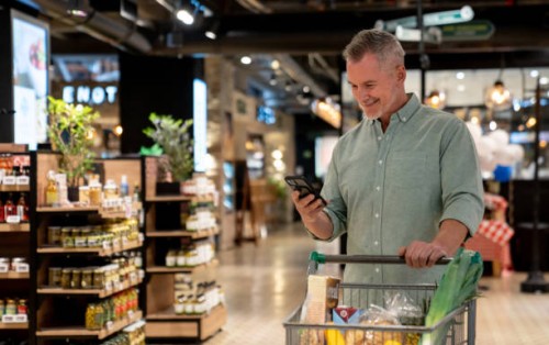 man buying groceries at the supermarket following a shopping list - food stock pictures, royalty-free photos & images