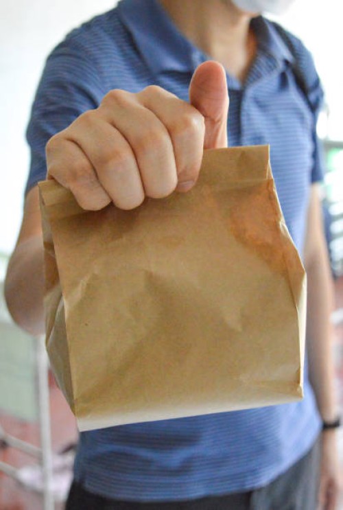 man carrying brown paper bag, lunch bag - junk food stock pictures, royalty-free photos & images