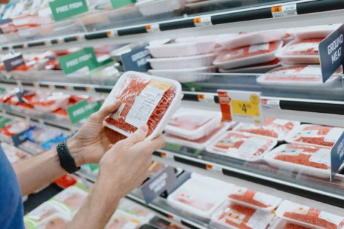 man checks price of ground beef at supermarket - food stock pictures, royalty-free photos & images