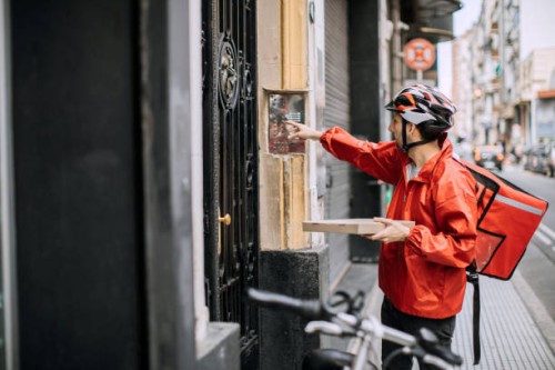 man delivering food and looking for right apartment - junk food stock pictures, royalty-free photos & images