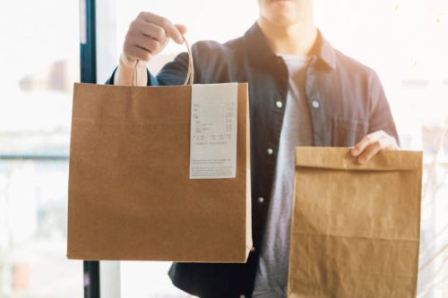 man delivering takeaway food at the front door - junk food stock pictures, royalty-free photos & images