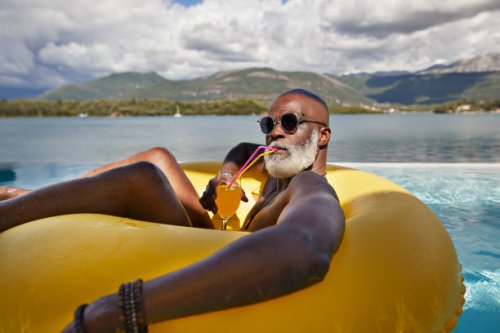 man drinking juice in inflatable ring - travel stock pictures, royalty-free photos & images