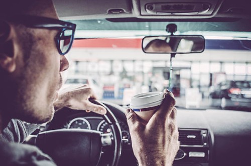 man driving his car and drinking take away coffee - junk food stock pictures, royalty-free photos & images