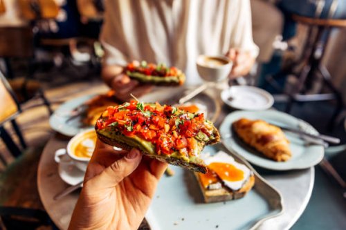 man eating avocado toast with tomato at the cafe, personal perspective view - food stock pictures, royalty-free photos & images