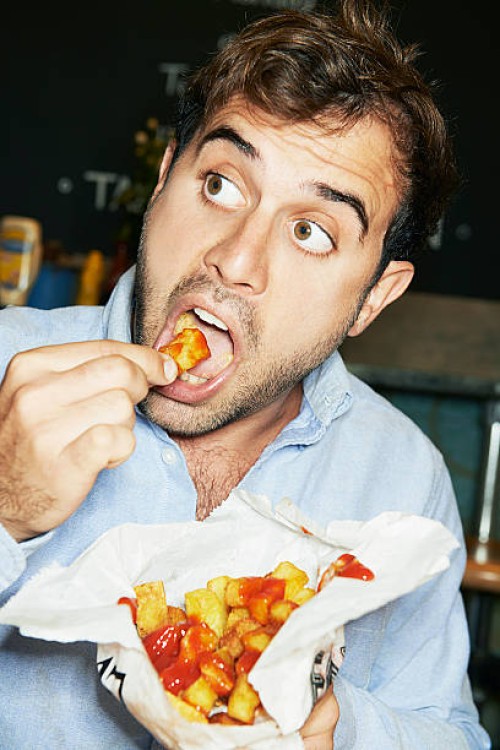 man eating bag of chips - food stock pictures, royalty-free photos & images