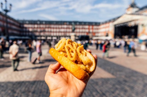 man eating bocadillo de calamares (calamari sandwich) on the street, personal perspective view - junk food stock pictures, royalty-free photos & images