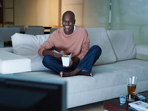 man eating chinese food watching television - junk food stock pictures, royalty-free photos & images