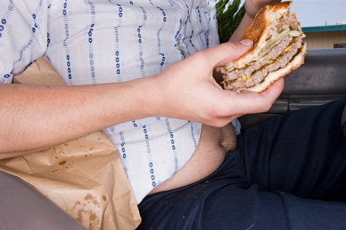 man eating fast food in his car - junk food stock pictures, royalty-free photos & images