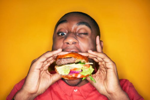 man eating hamburger - junk food stock pictures, royalty-free photos & images