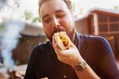 man eating hot dog at yard - junk food stock pictures, royalty-free photos & images