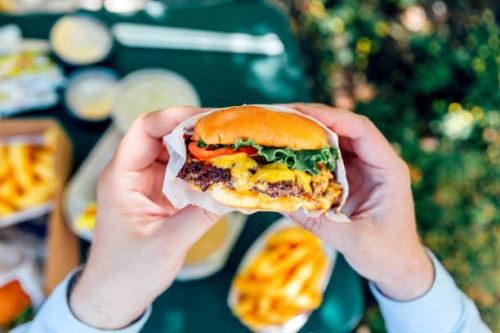 man eating juicy cheeseburger, personal perspective view - junk food stock pictures, royalty-free photos & images