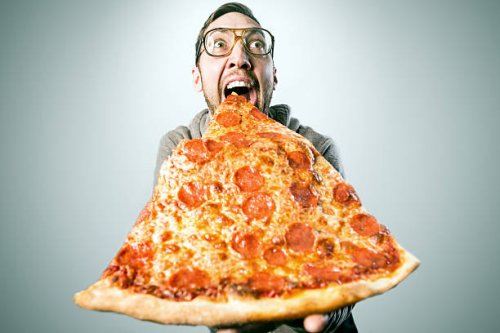man eating oversized pizza slice - junk food stock pictures, royalty-free photos & images