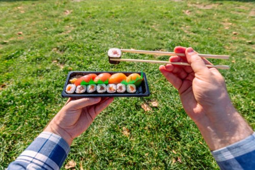 man eating takeaway sushi in the park, personal perspective view - junk food stock pictures, royalty-free photos & images