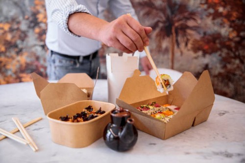 man eats takeaway sushi at home - junk food stock pictures, royalty-free photos & images