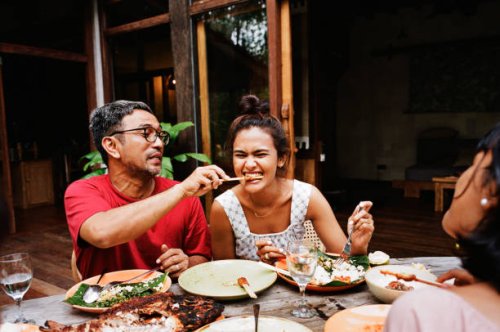 man feeding snack to woman at dining table - food stock pictures, royalty-free photos & images
