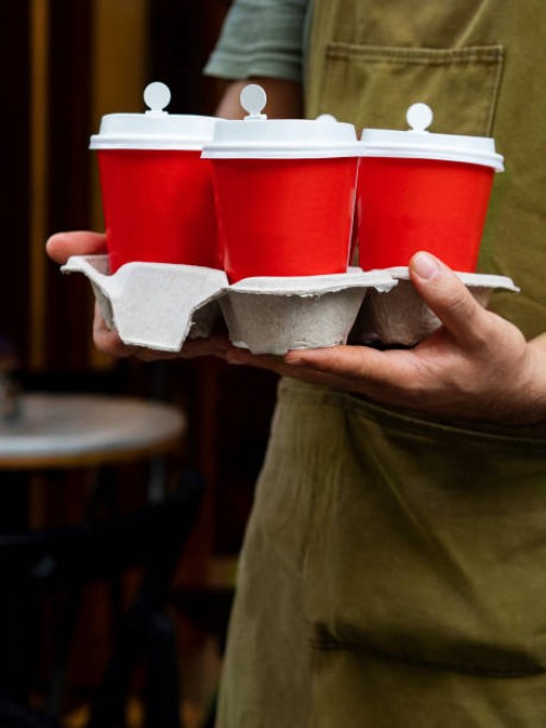 man holding paper cup of coffee, takeaway coffee, barista carrying take out coffee on delivery tray, your take-away coffee is ready - junk food stock pictures, royalty-free photos & images