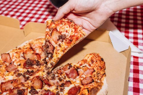 man holding pizza slice - junk food stock pictures, royalty-free photos & images