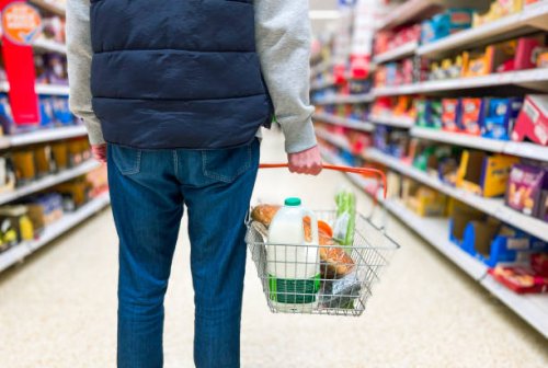 man holding shopping basket with bread and milk groceries in supermarket - food stock pictures, royalty-free photos & images