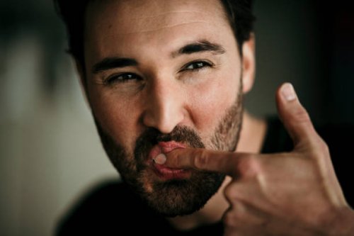 man licking index finger - food stock pictures, royalty-free photos & images
