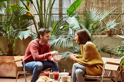 man looking at woman while having breakfast - garden decoration photos et images de collection