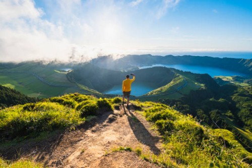 man on top of a mountain photographing volcanoes in sao miguel, azores - travel stock pictures, royalty-free photos & images