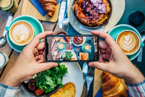 man photographing breakfast in a cafe with smartphone - food stock pictures, royalty-free photos & images