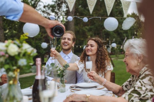 man pouring champagne into glasses for a toast at garden party. - garden decoration stock pictures, royalty-free photos & images