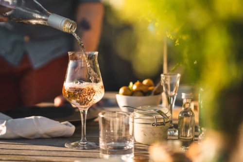 man pouring up rose wine at midsummer dinner - garden decoration stock pictures, royalty-free photos & images