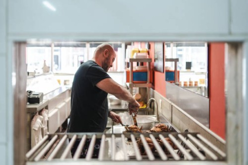 man preparing a delivery in a rotisserie shop - junk food stock pictures, royalty-free photos & images
