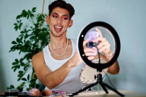 man putting on makeup in front of mobile phone using ring of light - fashion stock pictures, royalty-free photos & images