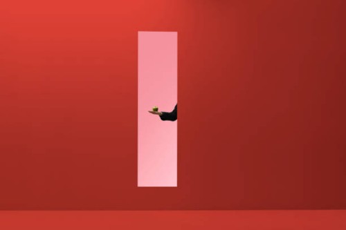 man reaching hand out threw rectangular opening in coloured wall and holding apple - food stock pictures, royalty-free photos & images